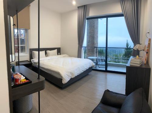 a bedroom with a bed and a large window at Famille Hotel - Central hotel in Dalat in Xuan An