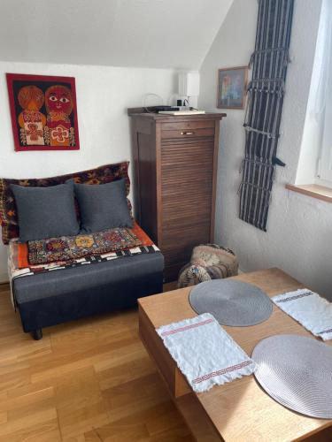 a small bedroom with a bed and a table at Small attic apartment close to Lake and Mountains Fussach in Fußach