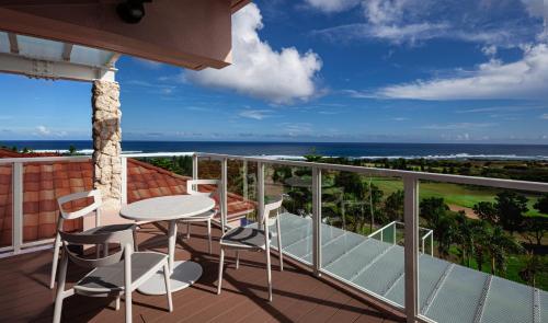 a balcony with a table and chairs and the ocean at The Shigira in Miyako Island