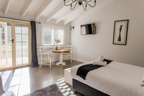 a bedroom with a bed and a table with chairs at Chez Vous Villas Pokolbin in Pokolbin