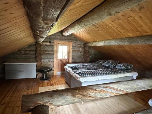 a bedroom with a bed in a log cabin at Arctic Private Island - All inclusive HB and activities in Rovaniemi