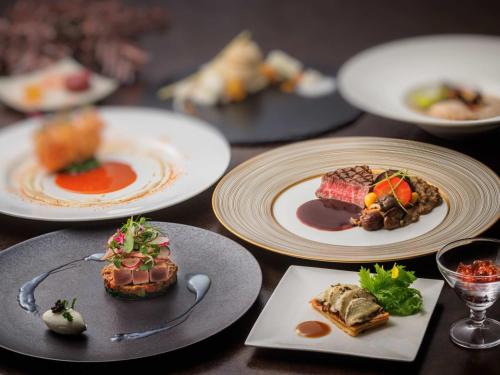 a wooden table with plates of food on it at Kamakura Prince Hotel in Kamakura