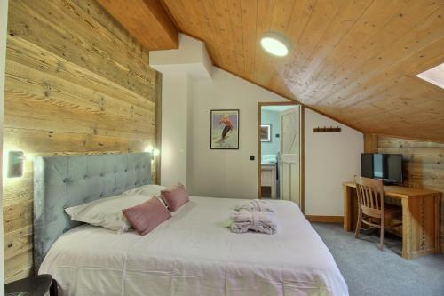a bedroom with a large bed with a wooden ceiling at ARC 1950 - Appartement 8 personnes Duplex Cheminée - ski aux pieds - Sauna, Hammam, Jacuzzi, Piscine in Arc 1950