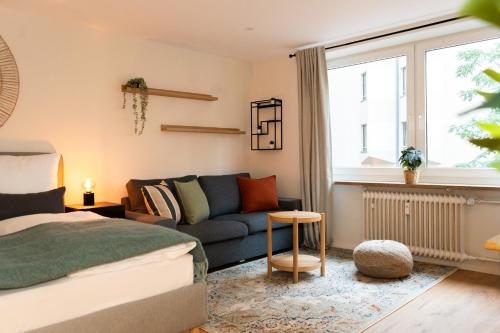 a living room with a bed and a couch at Renovated Munich City Center Apartment near Oktoberfest in Munich