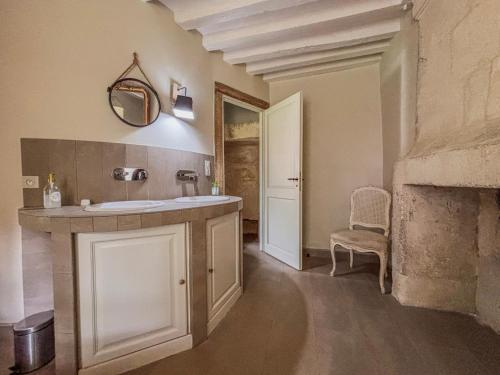 ein Badezimmer mit Waschbecken und Spiegel in der Unterkunft Le manoir de Saint-Ouen avec piscine chauffée intérieure in Saint-ouen-de-la-Cour