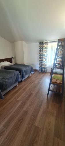 a bedroom with a bed and a wooden floor at Guest House Shina in Omalo