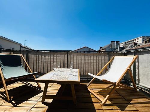 twee stoelen en een tafel op een balkon bij Casa Arcade Rougé - Premium - Terrasse - Parking in Cholet