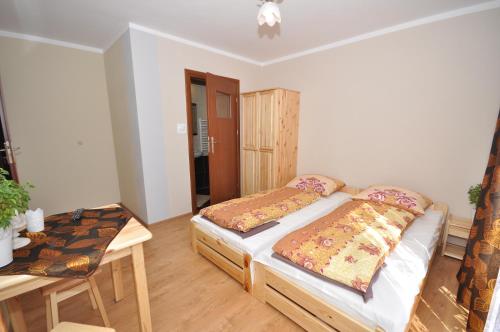 a bedroom with two beds and a table and a table at DW Dunajecki Gościniec in Biały Dunajec