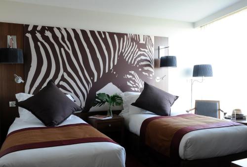 a hotel room with two beds with a zebra headboard at Radisson Blu Hotel, Montpellier in Montpellier