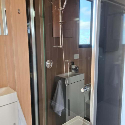 a bathroom with a shower with a toilet and a sink at Oceans Edge Retreat by Tiny Away in Portland