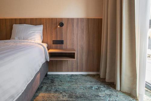 a bedroom with a bed and a wooden wall at Hunzego Hotel in Uithuizermeeden