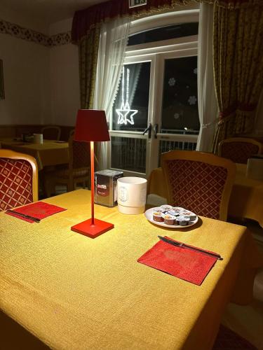 a table with a lamp and a plate of food on it at Hotel Sant'Ilario in Rovereto