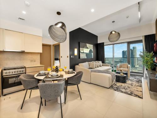 a kitchen and living room with a table and a couch at SmartStay at Burj Royale - Unique Downtown Dubai City Views - Brand New Luxury Apartments in Dubai