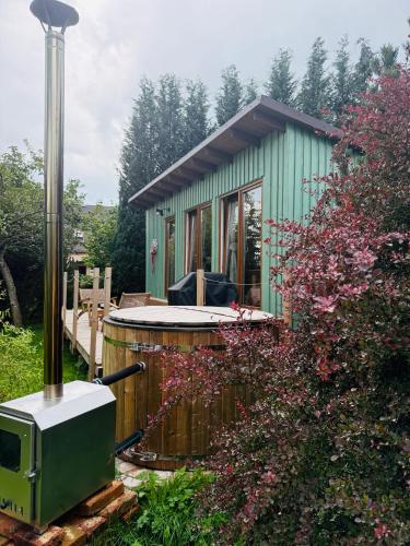 a green tiny house with a hot tub in a yard at Sakura Tiny house in National park,salty pool in Staré Křečany