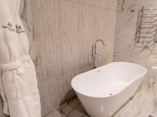 a bathroom with a white tub and a sink at Shirvan Grand Hotel Shamakhi in Şamaxı