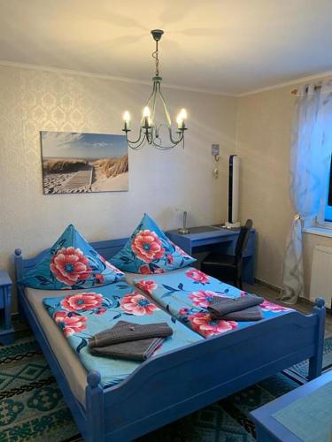 a bedroom with a blue bed with flowers on it at Hotel Auberge Restaurant in Schorfheide