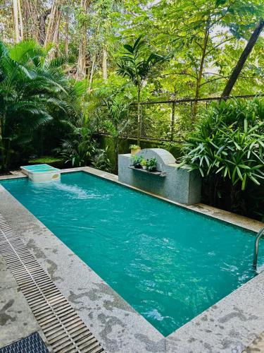 a swimming pool with blue water in a garden at El Reino by The Blue Kite - 2 & 3BHK Apartments, 5 Mins to Casino & 10 Mins to Candolim, with Pool & Kitchen, Wifi, Security in Verem