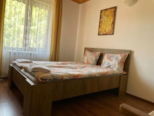 a bed sitting in a room with a window at Guest House Robin Hud in Cherni Osŭm