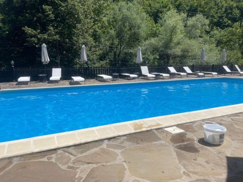 a swimming pool with lounge chairs and umbrellas at Guest House Robin Hud in Cherni Osŭm