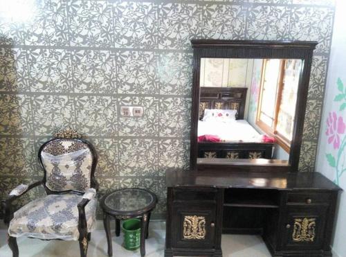 a bedroom with a desk and a mirror and a bed at Food Qila Hotel & Guest House in Dargai
