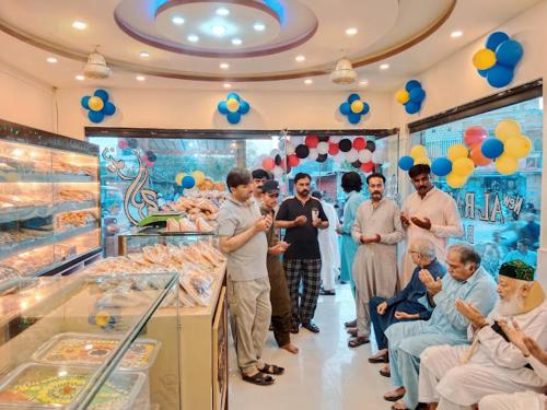 a group of people standing around in a store at Food Qila Hotel & Guest House in Dargai