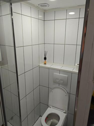 a small white tiled bathroom with a toilet at Eastern in Tilburg