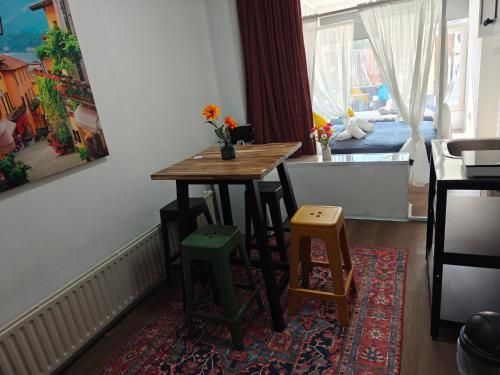 a kitchen with a table and stools on a rug at Eastern in Tilburg