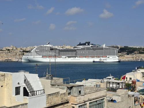 a cruise ship is docked in the water at Medieval Knights house GF with Seaview at the Three Cities Marina in Senglea