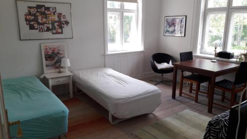 a bedroom with a bed and a desk and a table at bedandshower in Copenhagen