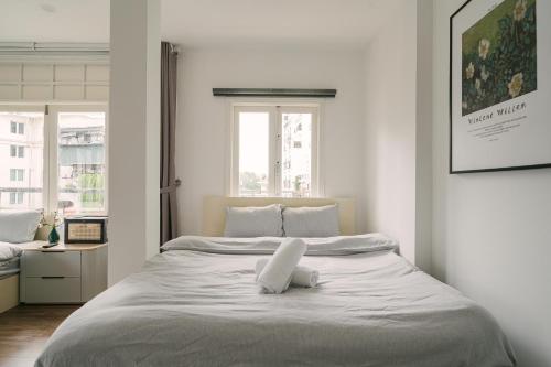 a white bedroom with a large white bed in it at Chez Lumi Hotel in Hanoi