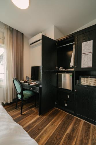 a bedroom with a desk and a bed and a desk at Chez Lumi Hotel in Hanoi
