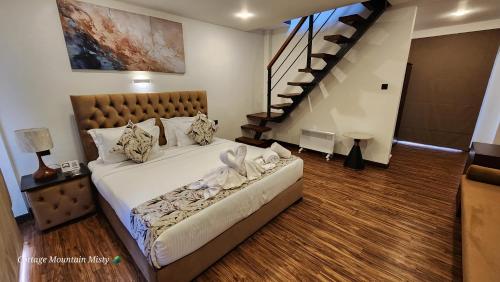 a bedroom with a large bed and a staircase at Cottage Mountain Misty-Nuwaraeliya in Nuwara Eliya