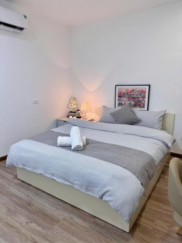 a large white bed in a bedroom with a white wall at Chez Lumi Hotel in Hanoi