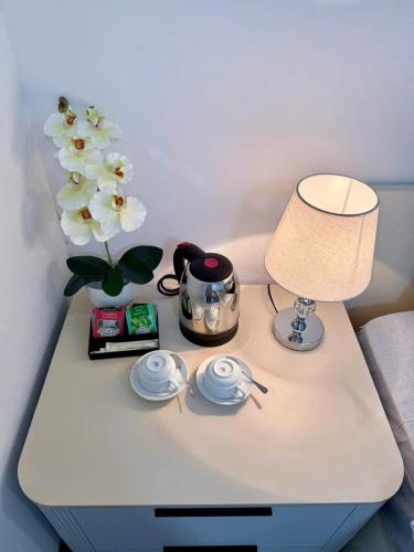 a table with a lamp and a vase with flowers on it at Chez Lumi Hotel in Hanoi