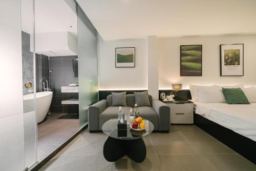 a bedroom with a bed and a couch and a table at Chez Lumi Hotel in Hanoi