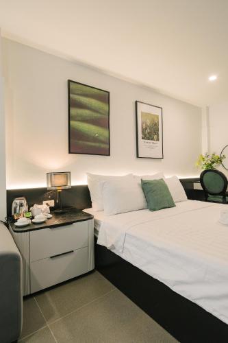 a hotel room with two beds and a desk at Chez Lumi Hotel in Hanoi