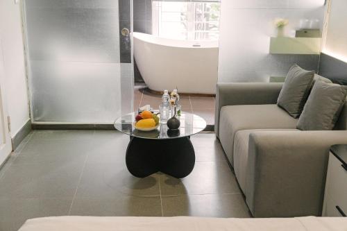 a living room with a couch and a glass table at Chez Lumi Hotel in Hanoi