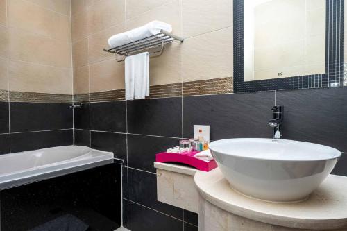 a bathroom with a white sink and a mirror at Becamex Hotel New City in Thu Dau Mot
