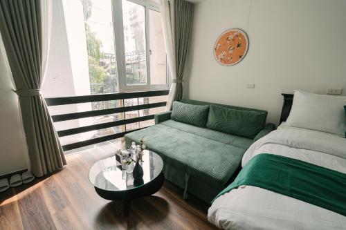 a room with a bed and a couch and a table at Chez Lumi Hotel in Hanoi