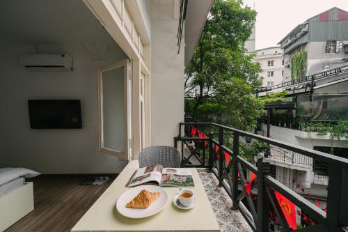 a table with a plate of food on a balcony at Chez Lumi Hotel in Hanoi