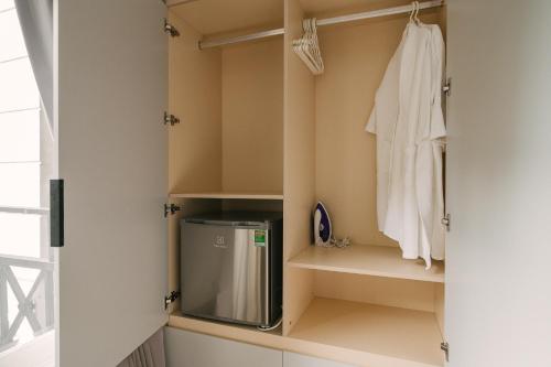 a walk in closet with a white shirt and a towel at Chez Lumi Hotel in Hanoi