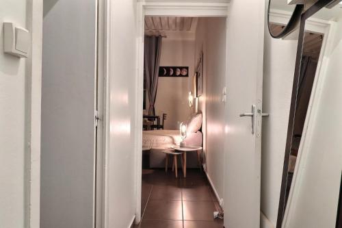 - un couloir avec une chambre dotée d'un lit et d'une table dans l'établissement Nest in heart of Lyon, à Lyon