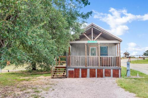 a small house with a staircase in front of a tree at Tumble on Inn at Bent Tree Ranch in Lampasas