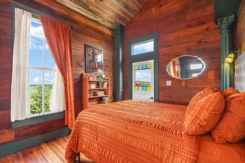 a bedroom with a bed in a room with wooden walls at Fleur de Tris at Bent Tree Ranch in Lampasas