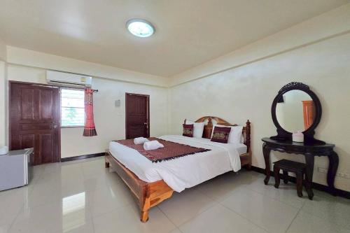 a bedroom with a large bed and a mirror at Baan Sabai Guesthouse in Chiang Mai