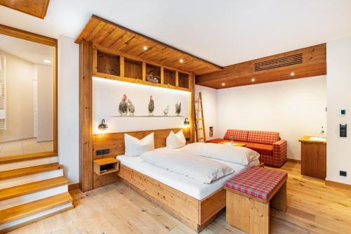 a bedroom with a bed and a bench in it at Wein- und Klimahotel Bergfriedel in Bühlertal