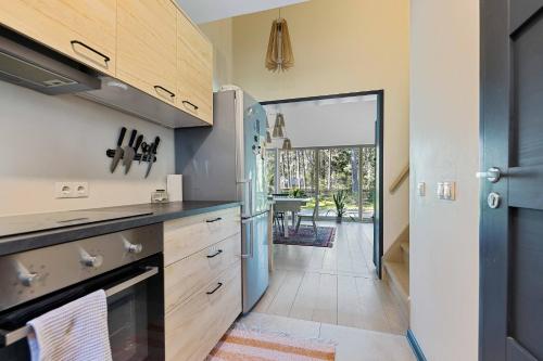 a kitchen with a refrigerator and a door leading to a patio at Pine forest beach house in Kloogaranna