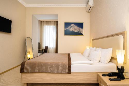 une chambre d'hôtel avec un lit et une montagne dans l'établissement Rustaveli Palace, à Tbilissi