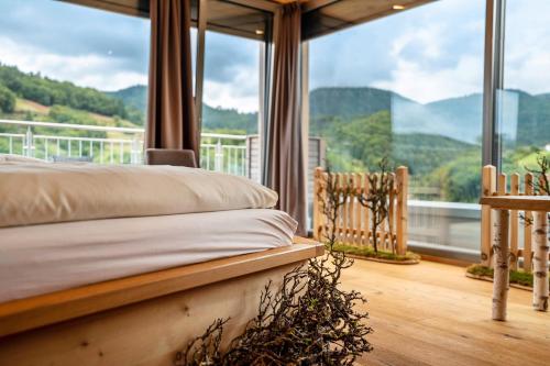 a bedroom with a bed in front of a large window at Wein- und Klimahotel Bergfriedel in Bühlertal
