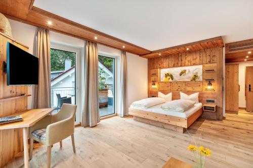 a bedroom with a bed and a desk at Wein- und Klimahotel Bergfriedel in Bühlertal